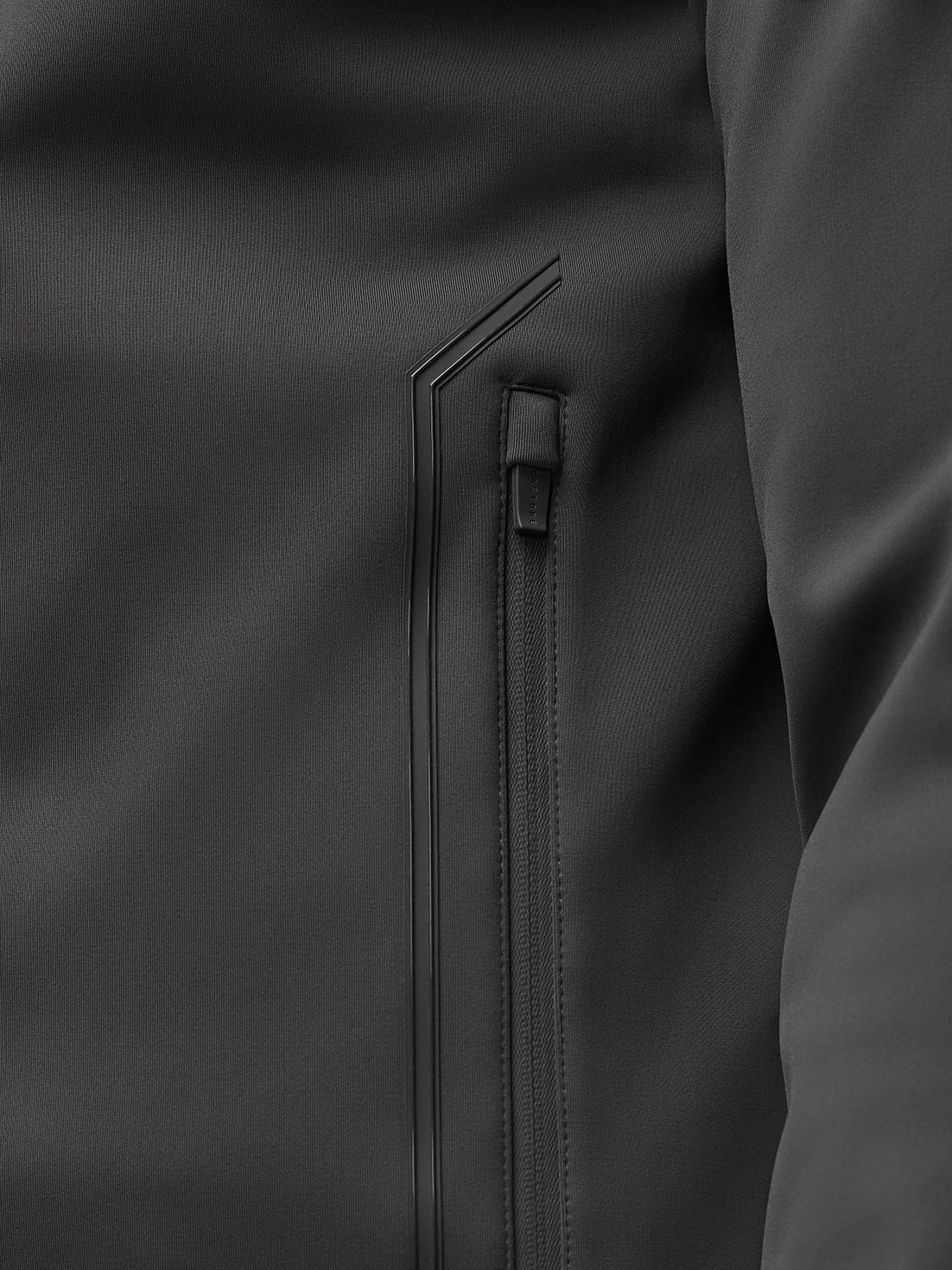 Close-up of charcoal Garcia Hybrid Jacket showing a water resistant zip pocket and seam detailing.
