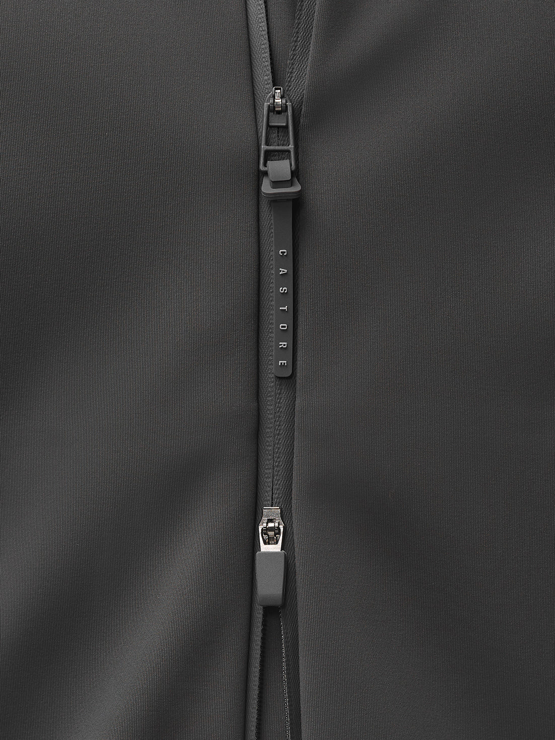 Close-up of a charcoal jacket zipper pull with CASTORE branding.