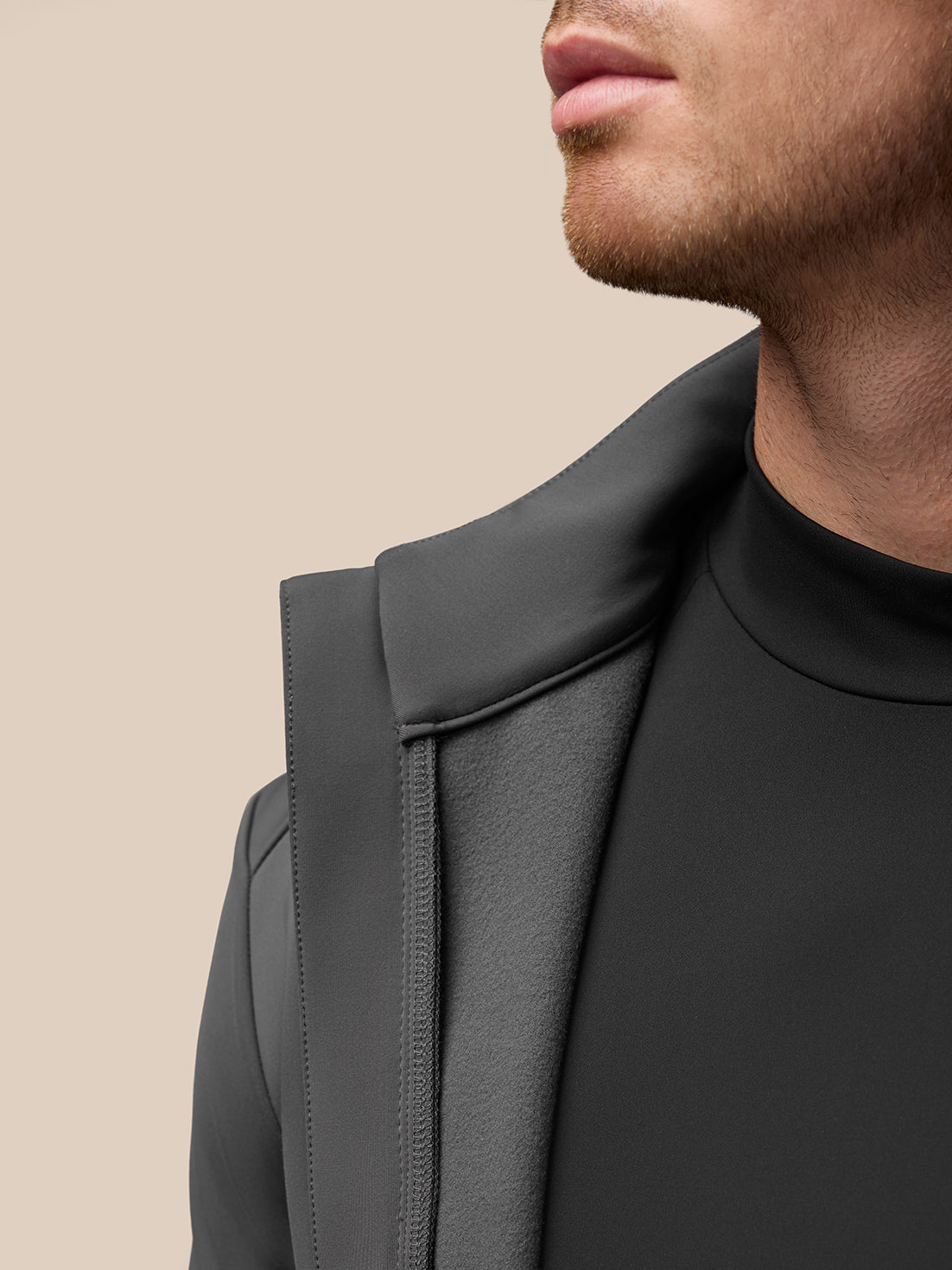 Close-up of the Garcia Hybrid Jacket collar and zipper on charcoal fabric showing seam details.