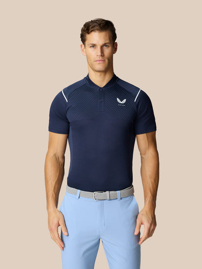 Male model in navy Pinnacle Golf LVS Polo with diagonal pattern and white piping, paired with light blue trousers