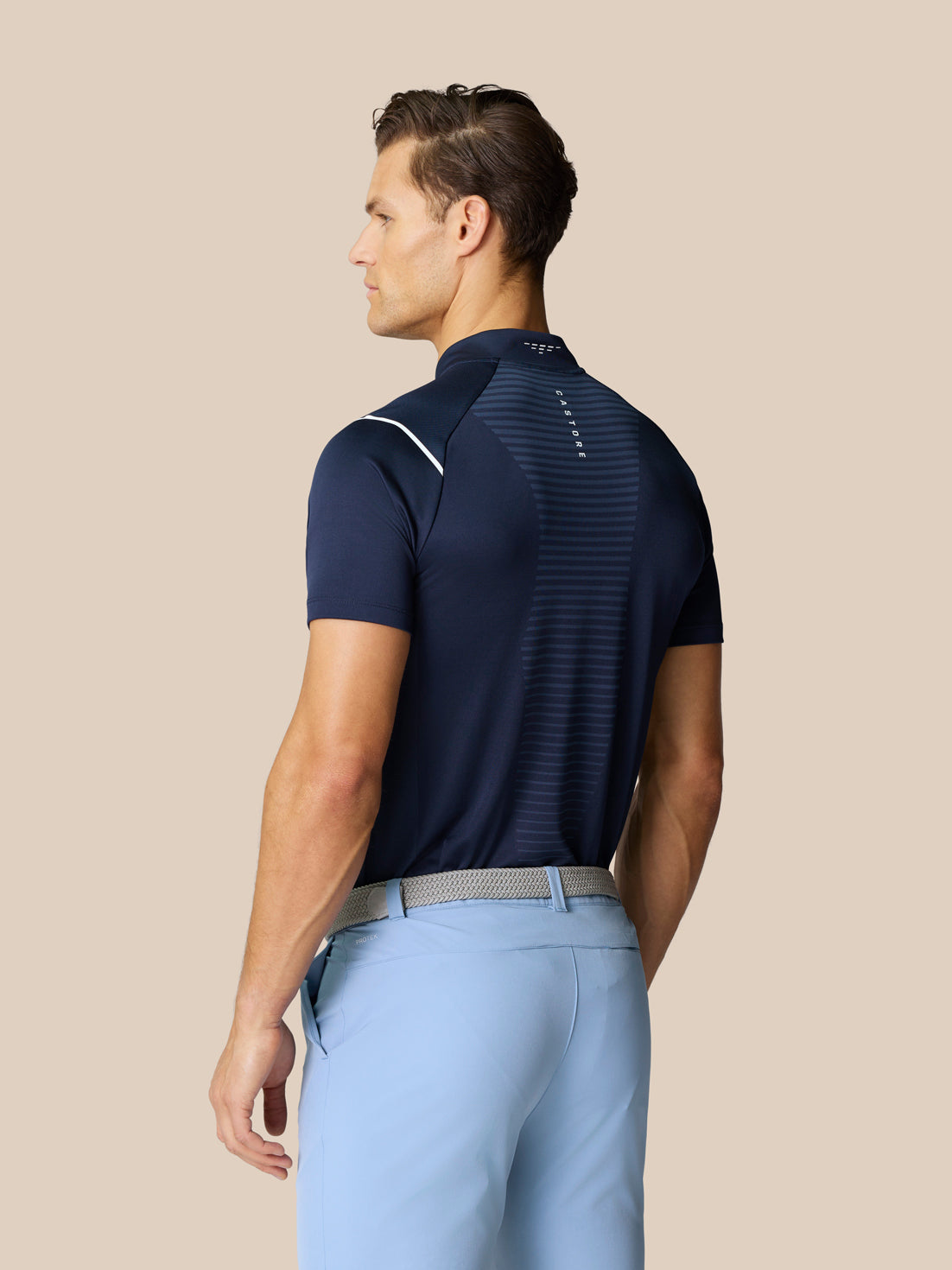 Rear view of a male model wearing the Pinnacle Golf LVS Polo in navy, highlighting the back panel and athletic fit