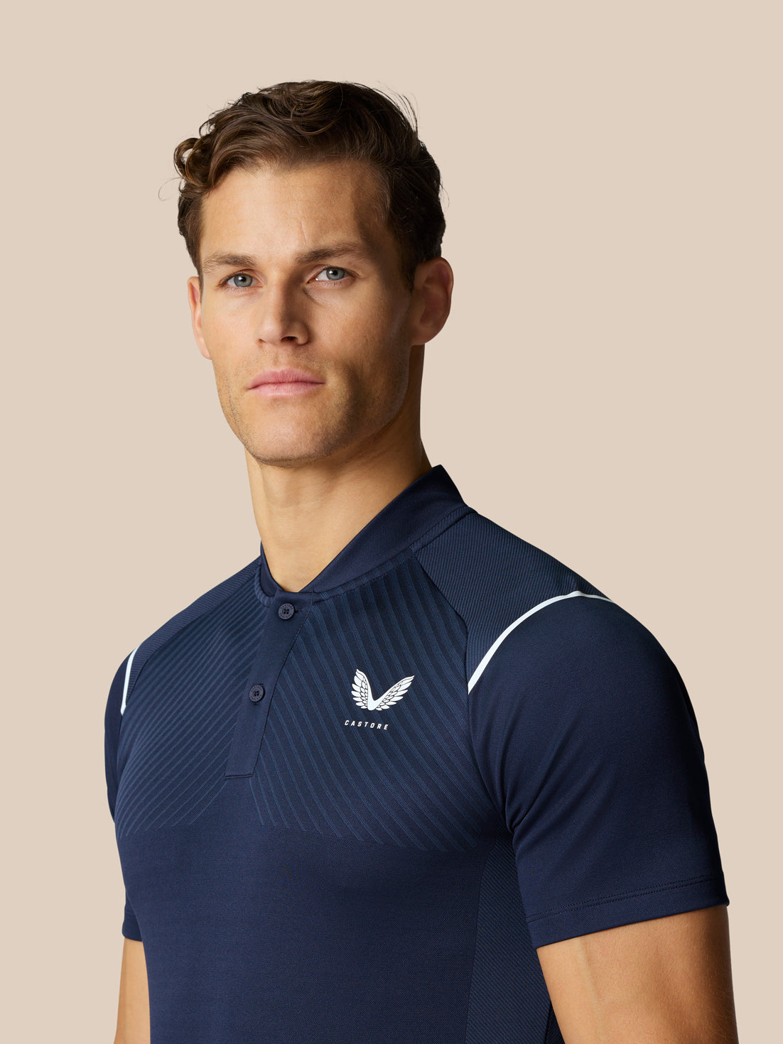 Male golfer in a navy Pinnacle Golf LVS Polo front view with crest logo on the chest