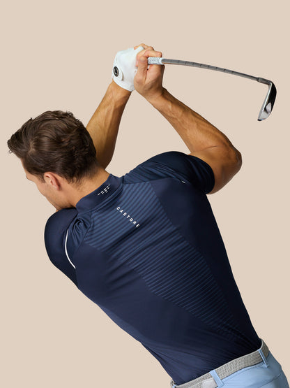 Male golfer wearing a navy Pinnacle Golf LVS Polo mid swing with a club raised overhead and a white glove