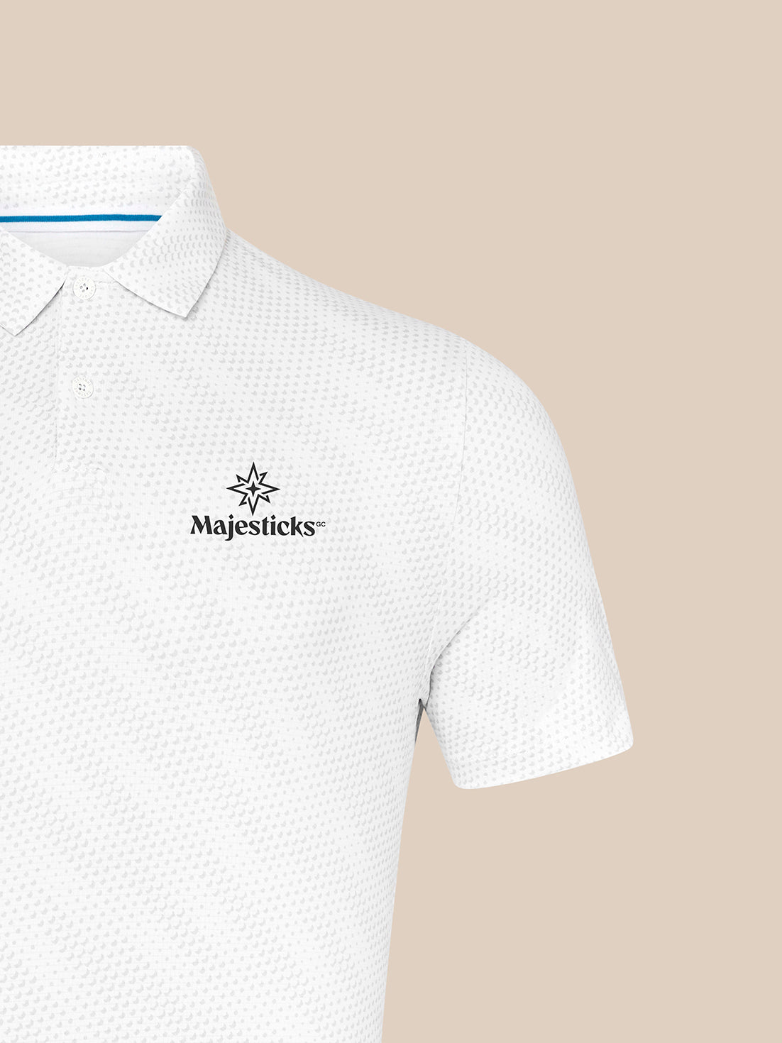 White Majesticks polo with golf ball print and left chest logo against a beige background