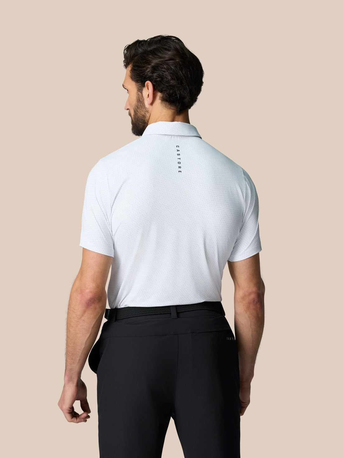 Back view of a white Club Graphic Polo on a male model showing Castore branding along the upper back