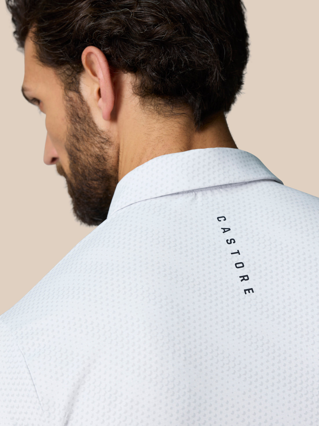 Back view of the white Club Graphic Polo with CASTORE branding running along the upper back.