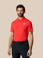Male model wearing a red golf polo with golf ball print across the fabric and a small chest logo.