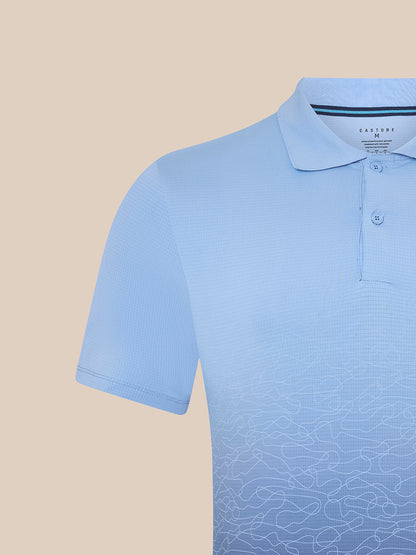 Close-up of sky blue Majesticks golf polo with collar and two buttons, featuring an ombre scribble print on the front.