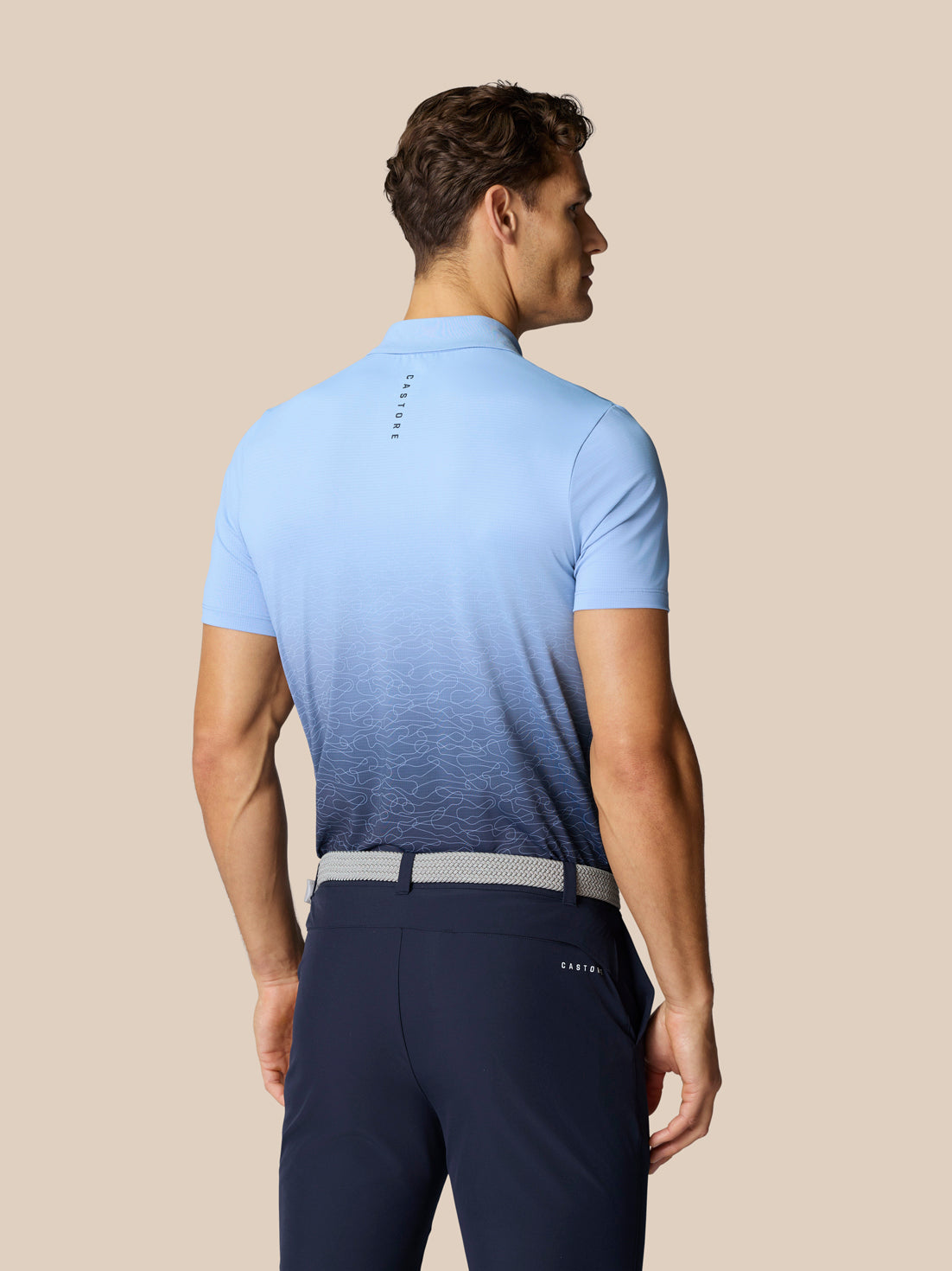 Back view of the sky blue Club Graphic Polo with gradient hem and Castore branding at upper back