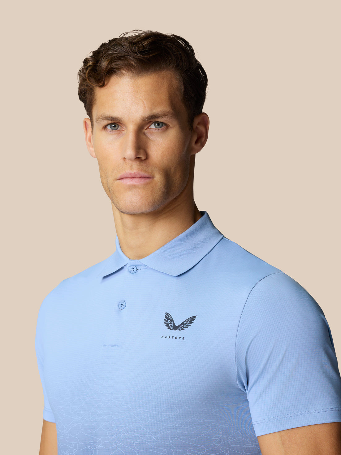 Male model wearing sky blue Club Graphic Polo with Castore logo on chest
