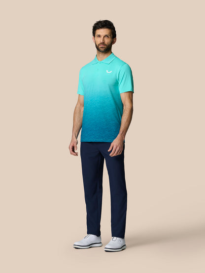 Full model wearing Club Graphic Polo Light Aqua with gradient ombre pattern left chest logo, navy pants and white shoes.