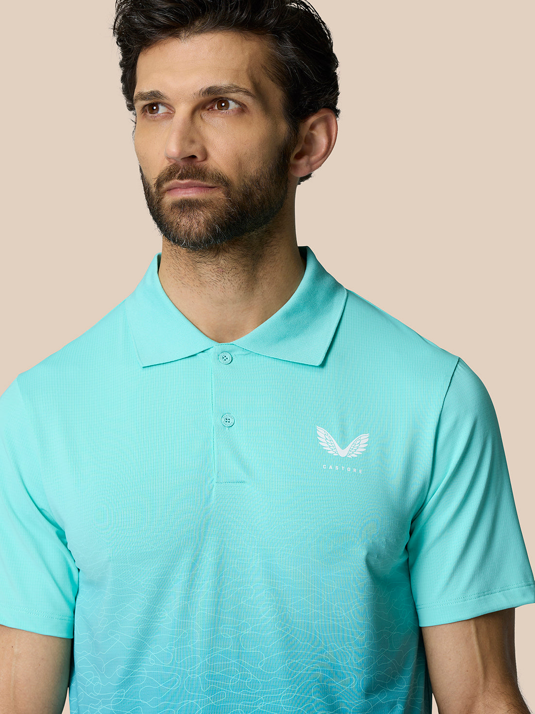 Front view of a man in the light aqua Club Graphic Polo with ombre pattern and Castore logo on the left chest
