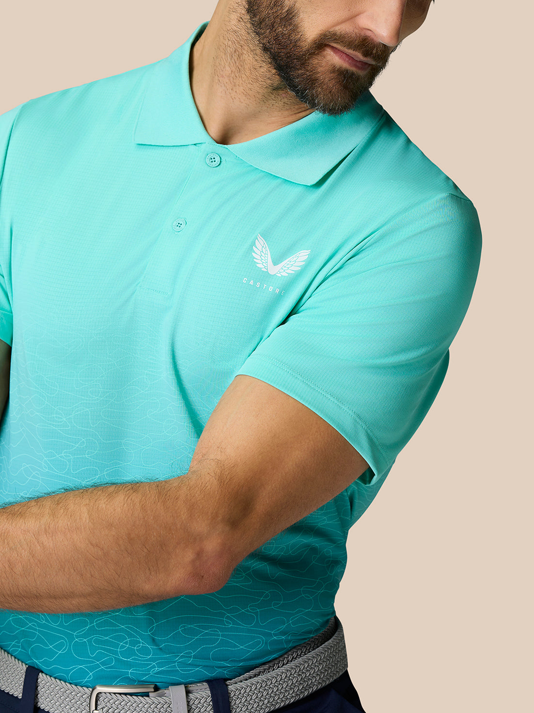 Close-up of the light aqua Club Graphic Polo showing the chest logo and textured fabric at the sleeve area