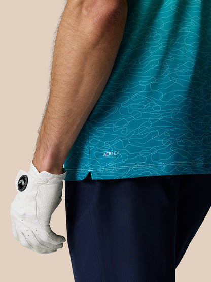 Close up of Club Graphic Polo in light aqua with teal ombre print and AERTEK branding at the hem, white golf glove visible.
