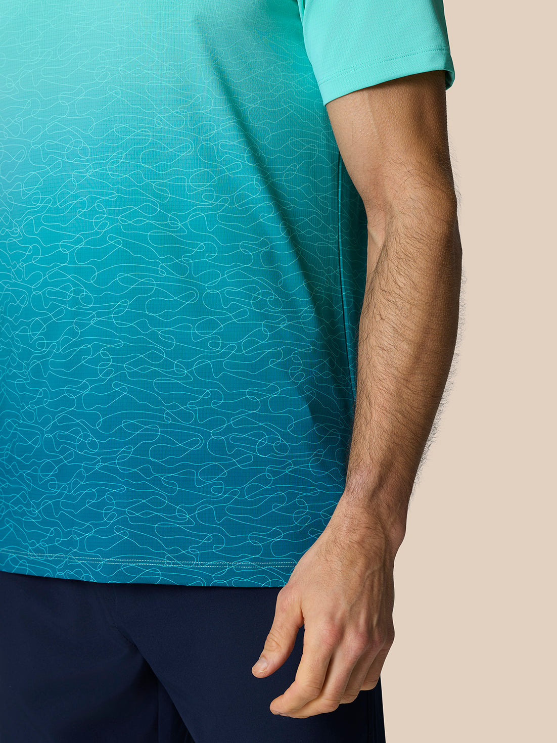 Model wearing Club Graphic Polo Light Aqua with ombre print and short sleeves.