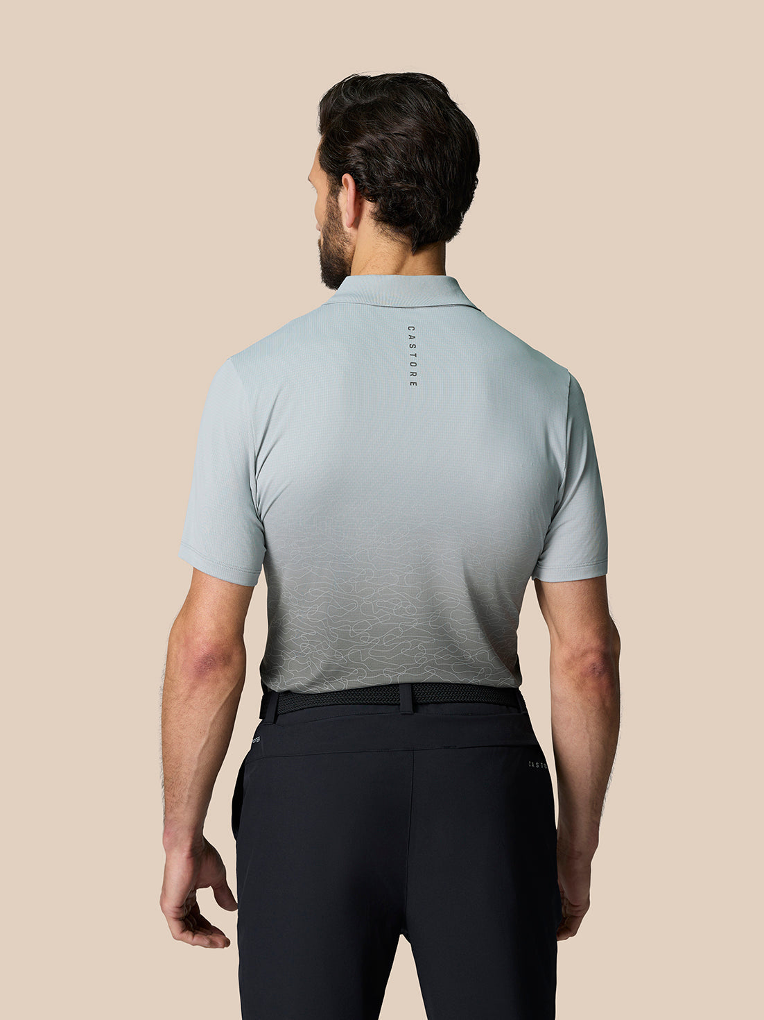 Back view of Club Graphic Polo in mid grey with gradient lower panel and Castore branding along the upper back.
