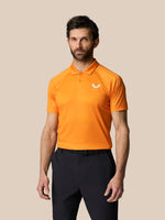 Male model wearing bright orange Club Graphic Polo Mango with white Castore logo on chest against a beige backdrop