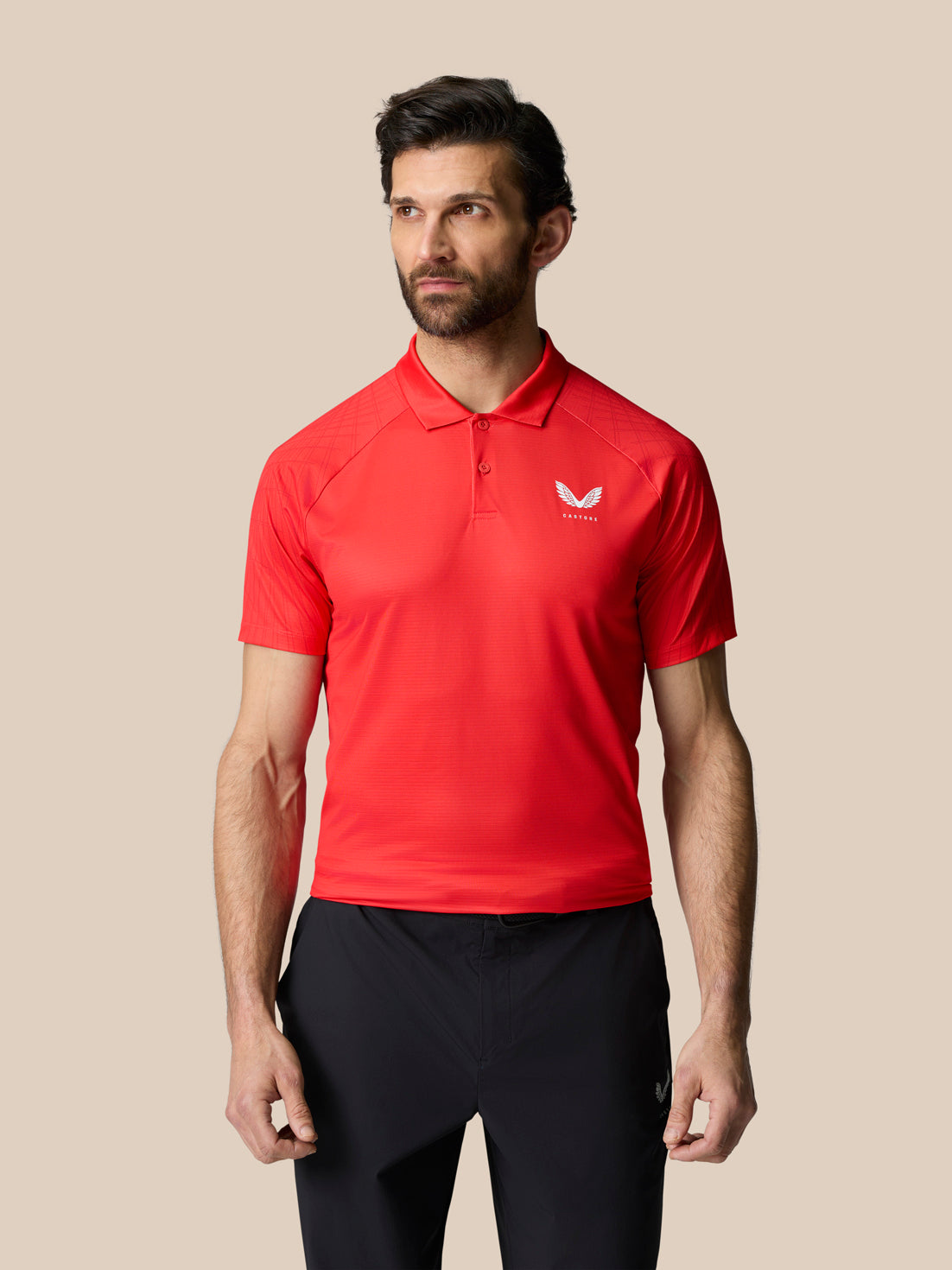 Male model wearing red Club Graphic Polo with polo collar and white Castore logo on the left chest.