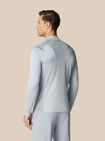 Man wearing Pinnacle LVS 1/4 Zip Top in mid grey seen from the back, highlighting the venting stripe down the spine.