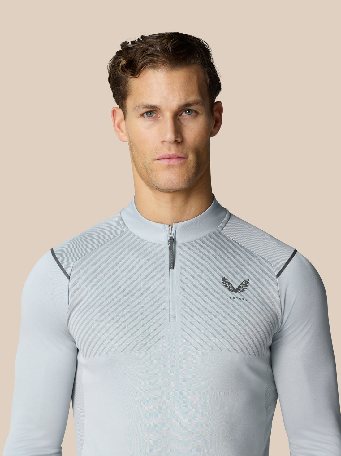 Front view of a man wearing the mid grey Pinnacle LVS 1/4 Zip Top with a quarter zip and vented knit pattern.