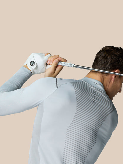 Golfer wearing Pinnacle LVS 1/4 Zip Top in mid grey during a swing, back view showing vented spine panel.
