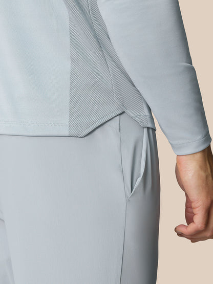 Close up of the back waist area of the Pinnacle LVS 1/4 Zip Top in mid grey showing the vent panel and curved hem.