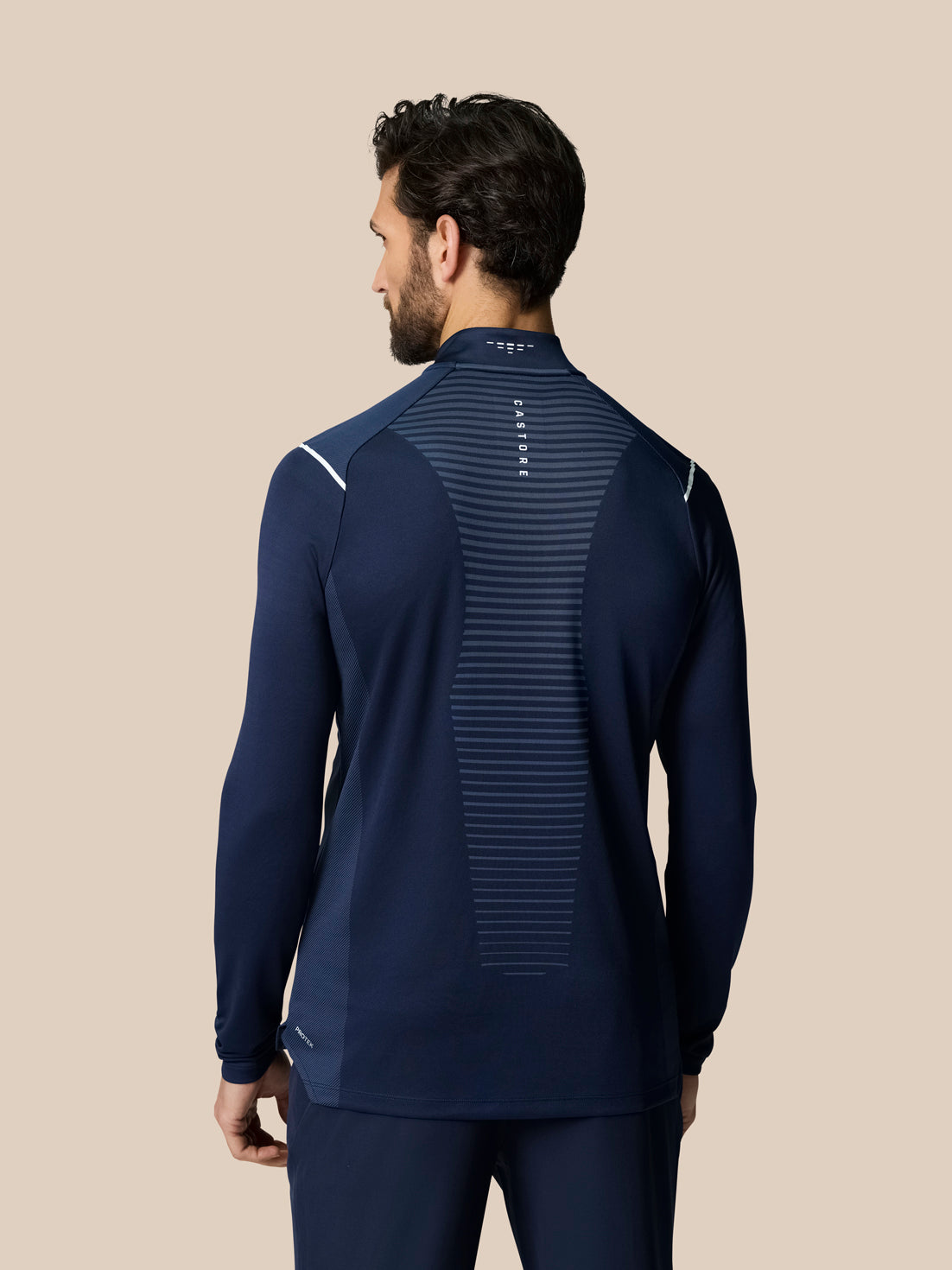 Back view of navy Pinnacle LVS 1/4 Zip Top with striped vent panel along the spine and Castore branding at the neck.