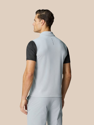 Back view of a man wearing a mid grey Club Classic half zip golf gilet with Castore graphic at the neckline.