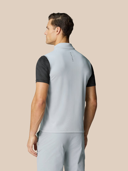 Back view of a man wearing a mid grey Club Classic half zip golf gilet with Castore graphic at the neckline.