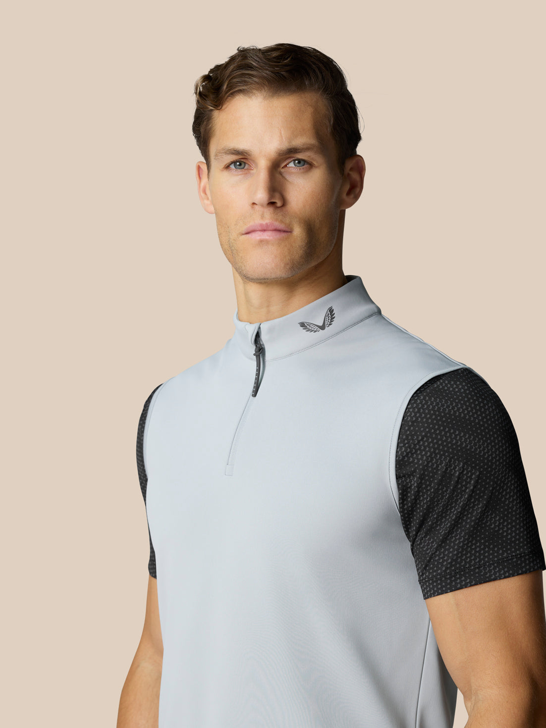 Close-up of a male model wearing the light grey Club Classic ½ Zip Gilet with a high collar.