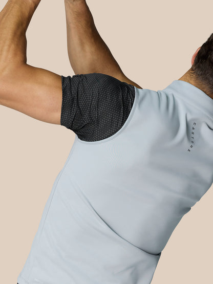 Side back view of a man in the light grey Club Classic half zip golf gilet over a black dotted sleeve, Castore lettering along the back neck.