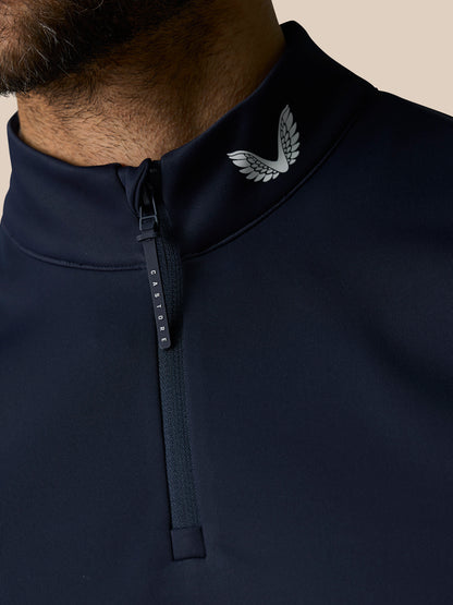 Close up of navy Club 1/2 Zip Gilet collar with zipper pull and Castore wing logo