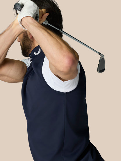 Side view of a man wearing navy sleeveless Club 1/2 Zip Gilet while lifting a golf club