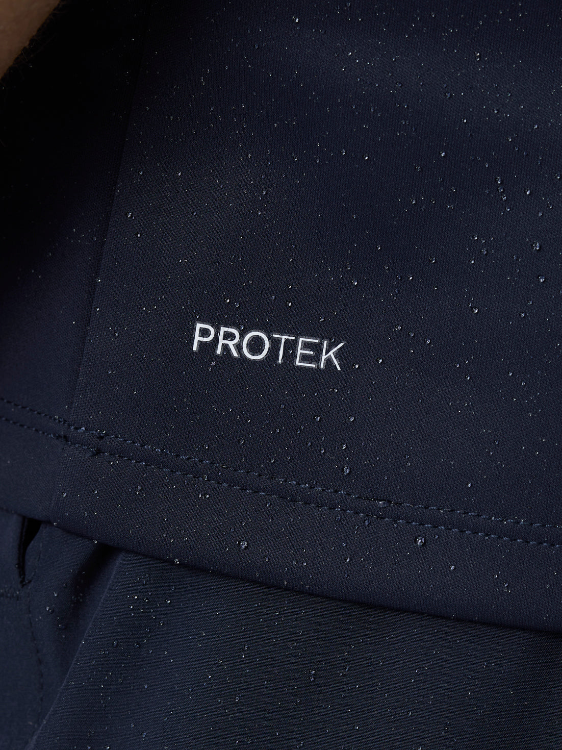 Close up of navy ProTek fabric with water droplets beading on the surface