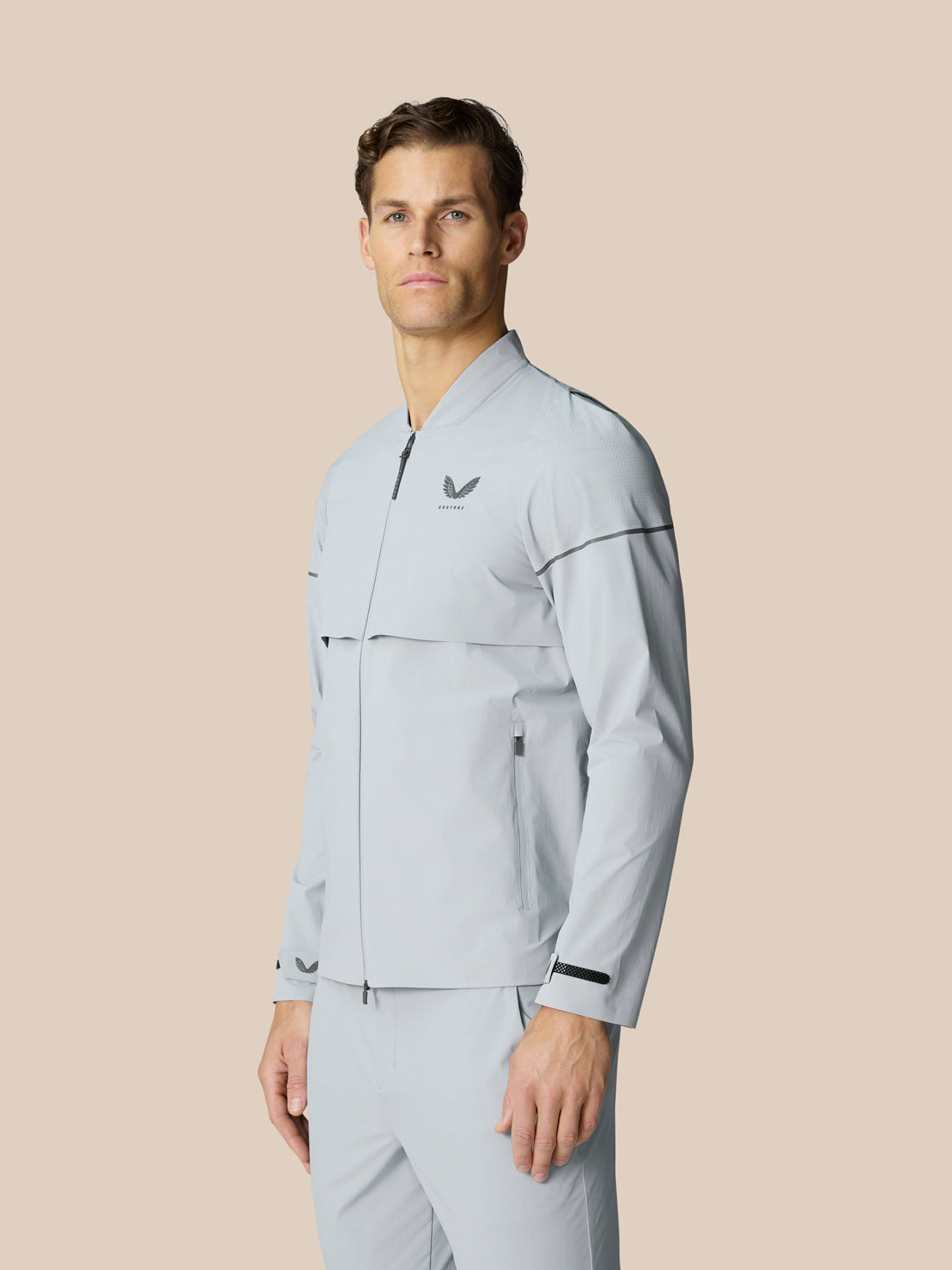 Light grey Golf Pinnacle LVS Woven Jacket worn by a male model with full zip front stand collar and zip pockets