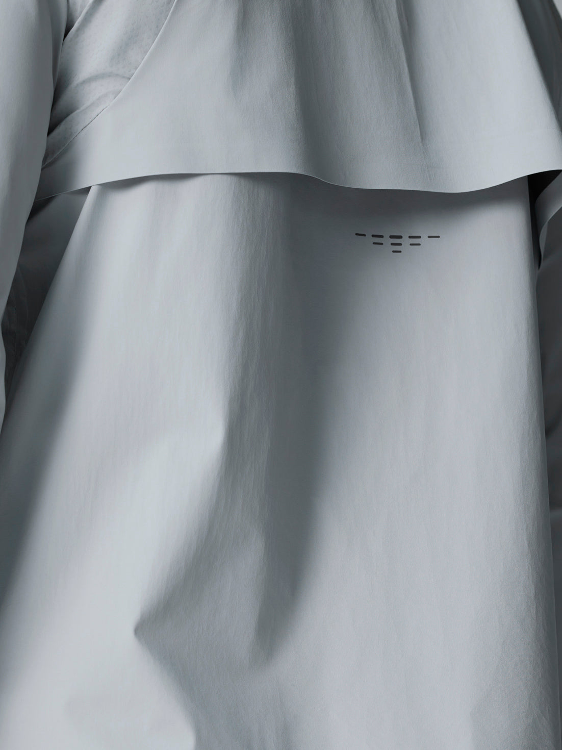 Front chest of the light grey Golf Pinnacle LVS Woven Jacket with zipper and Castore logo.
