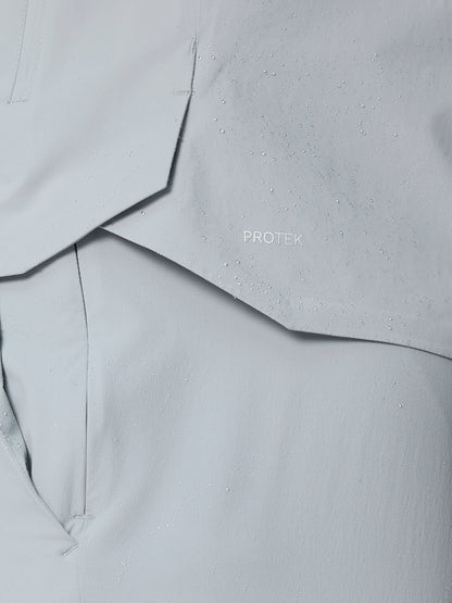 Close-up of light grey ProTek fabric from Golf Pinnacle LVS Woven Jacket with water droplets.