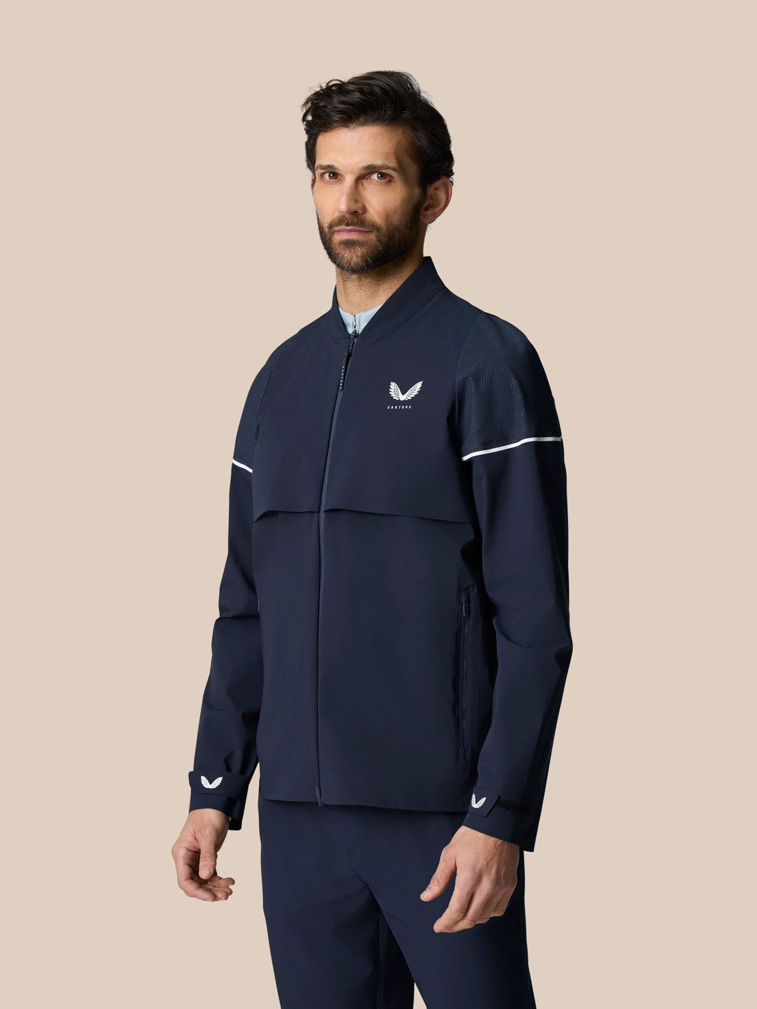 Male model wearing midnight navy Golf Pinnacle LVS Woven Jacket from the front