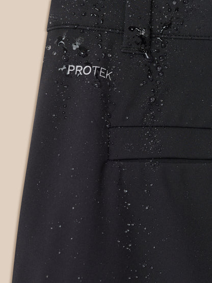 Close-up of black golf trouser fabric with water droplets and PROTEK logo