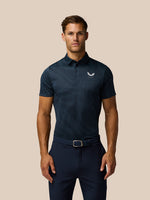 Male model wearing Pinnacle Glow Polo in midnight navy with striped knit pattern and left chest logo