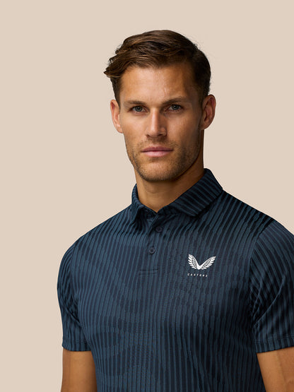 Front view of a man wearing a midnight navy striped golf polo with Castore logo on the left chest