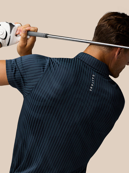 Rear three-quarter view of a man in a midnight navy striped golf polo holding a golf club across his back