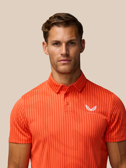 Close up of bright orange striped golf polo showing polo collar and Castore logo on left chest