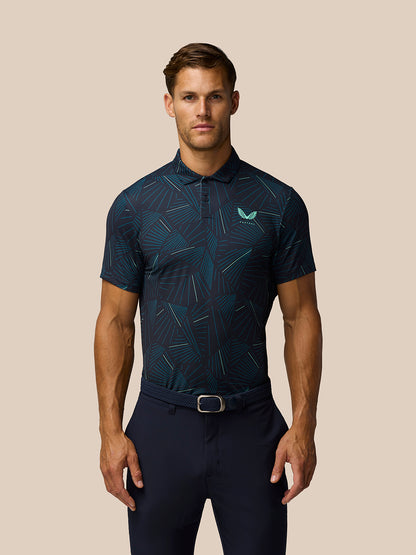 Male model wearing midnight navy printed golf polo with aqua geometric lines and Castore logo on left chest