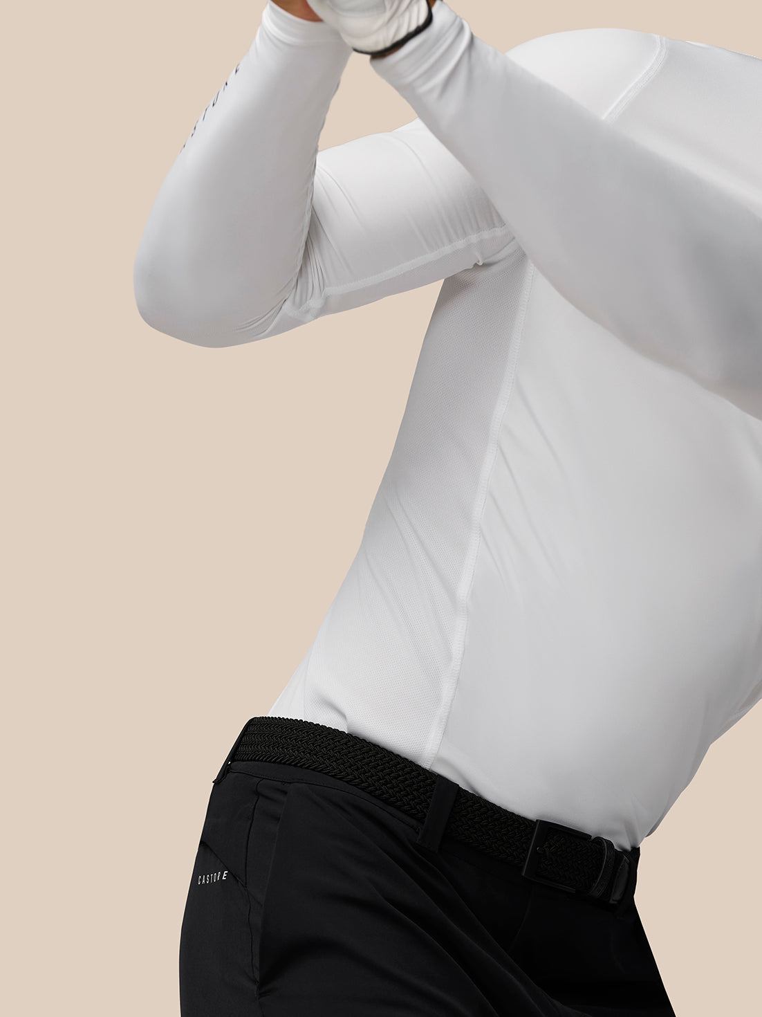Side profile of male model in white long sleeve Golf Club top with visible panel seams and textured fabric