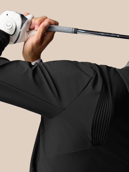 Golfer wearing a black Golf Pinnacle Performance Hoodie grips a golf club with a white glove