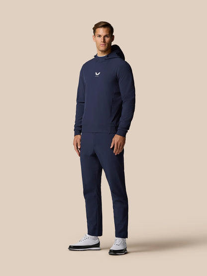 Male model in the Golf Pinnacle Performance Hoodie midnight navy standing in a full length shot showing the chest logo