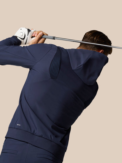 Rear view of a golfer wearing the Midnight Navy Pinnacle Performance Hoodie during a backswing, highlighting the slim athletic fit