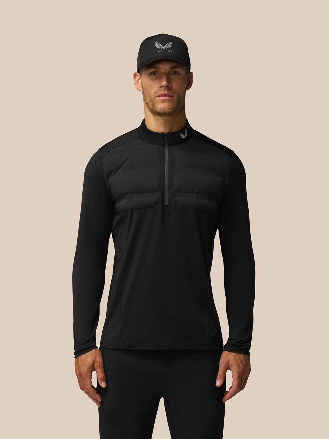 Male model wearing black Golf Pinnacle LVS Hybrid half zip top with padded chest panel