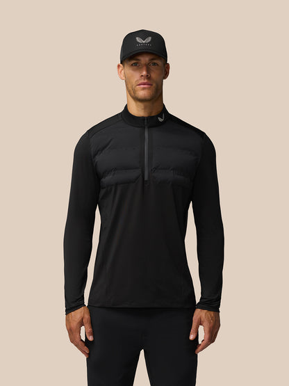 Male model wearing black Golf Pinnacle LVS Hybrid half zip top with padded chest panel